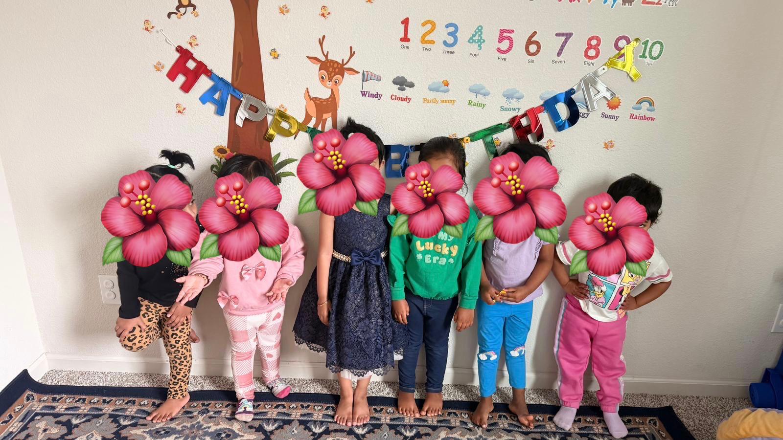 Children standing near a birthday banner