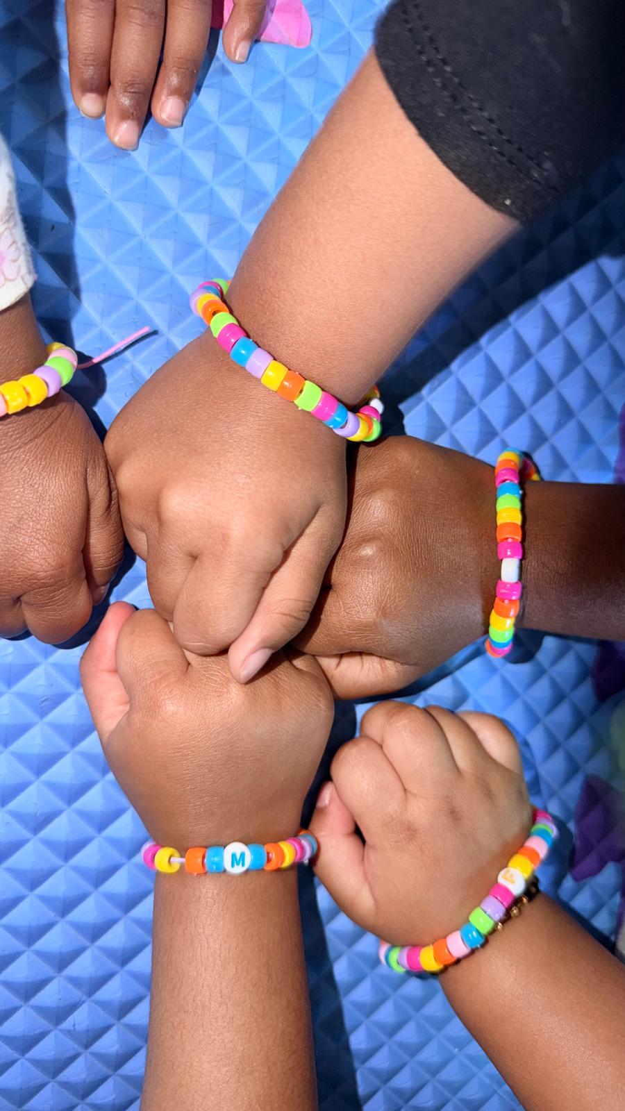 Children showing colorful craft bracelets